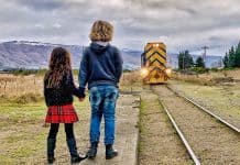 Children await the Taieri Gorge Railway train, Sutton Station, Dunedin, New Zealand.