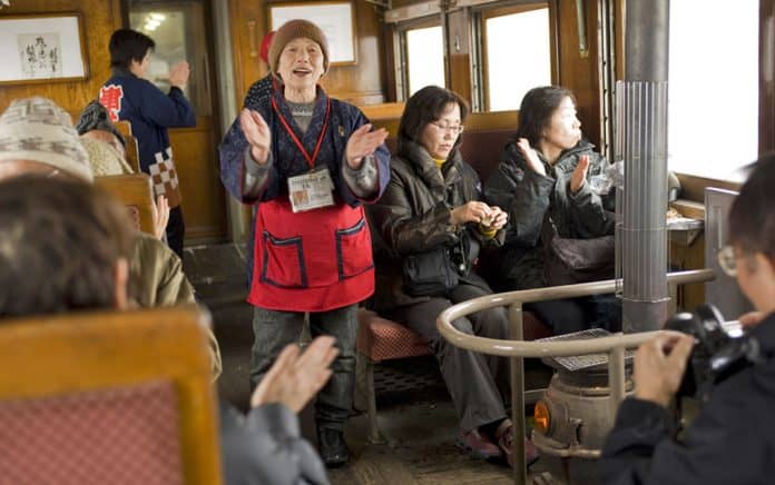 Passengers singing aboard the Tsugaru Railway stove train in Aomori, Japan.