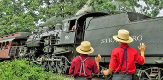 Amish boys wave as a steam train passes along Pennsylvania's Strasburg Rail Road.