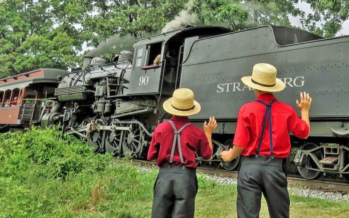Amish boys wave as a steam train passes along Pennsylvania's Strasburg Rail Road.